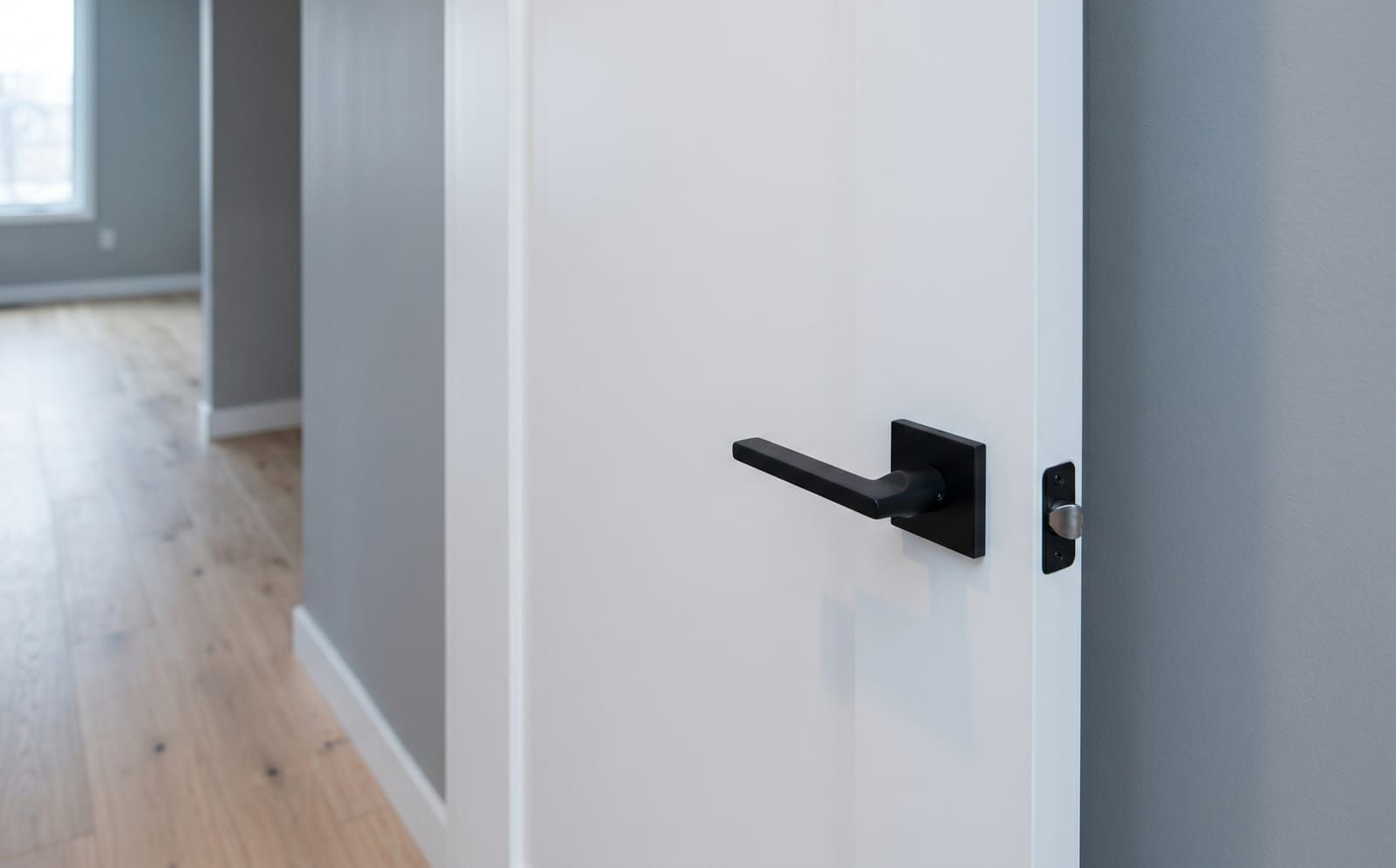 Modern flush-panel white interior door with matte-black lever